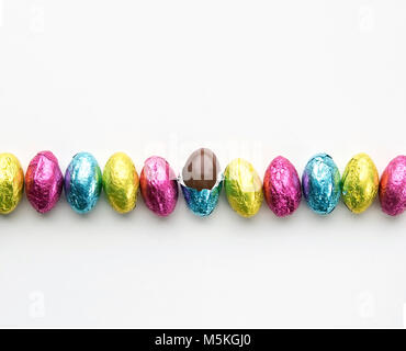 Foil wrapped easter candy in a row one candy unwrapped Stock Photo
