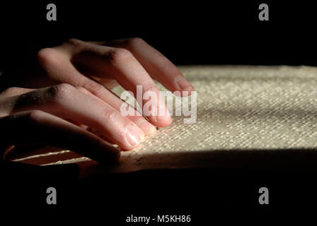 blind reading text in braille. close-up of human hands reading braille. Stock Photo