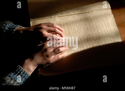 blind reading text in braille. close-up of human hands reading braille. Stock Photo
