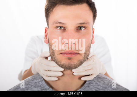 Doctor Performing Physical Exam Palpation Of The Thyroid Gland Stock Photo