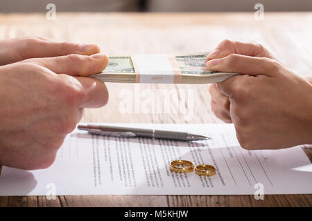 Couple's Fighting For Money Over The Divorce Agreement With Gold Wedding Rings Stock Photo