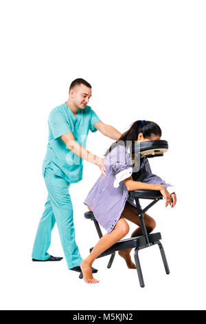 Theme massage and office. Male therapist with blue suit doing back and neck massage for young woman worker, business woman in shirt on massage chair s Stock Photo