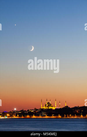 Blue Mosque and Hagia Sophia at twilight with crescent moon in the sky, Istanbul, Turkey. Stock Photo