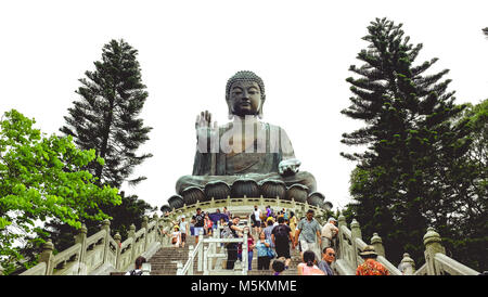Tourists are seen walking up the steps towards the big Buddha on Lantau Island in Hong Kong Stock Photo