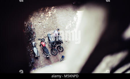 Man sitting on a motorbike in a car park in Mumbai, India Stock Photo