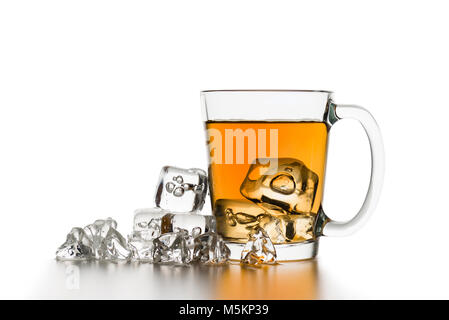 glass cup of tea with ice cubes on white table. Stock Photo