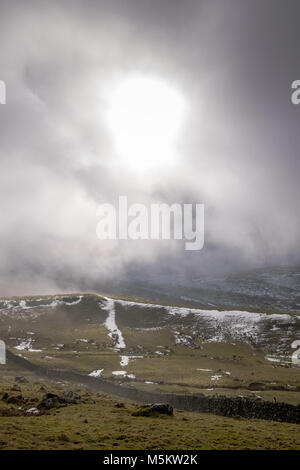 Patches of snow on fields seen through low clouds near the Settle Loop in theYorkshire Dales Stock Photo