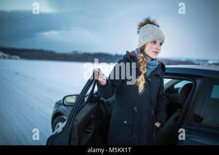 Woman driving a car - female driver at a wheel of a modern car, looking happy, smiling with a relaxed smile (shallow DOF; color toned image) Stock Photo