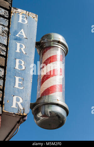 Traditional red and white barbers pole outside men's hairdressers Stock Photo