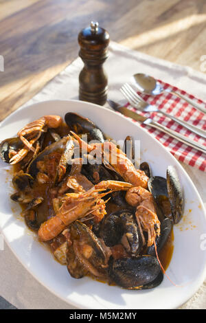 fish soup with prawns mussels and mixed fish in a serving dish Stock Photo