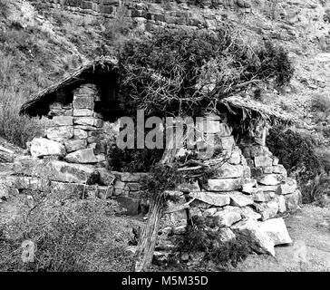 Grand Canyon Historic Bright Angel Trail  mile resthouse . THREE-MILE REST HOUSE ON THE BRIGHT ANGEL TRAIL WITH THATCH ROOF. CIRCA 1930. GRANT, Stock Photo