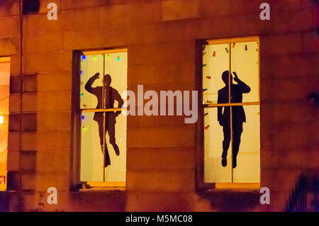 Glasgow, Scotland, UK. 24th February, 2018. Strathbungo Window Wanderland is a magical walking trail for all the family around the southside streets of Glasgow after dark where the residents have put on a wonderful outdoor gallery display for the public. Pictured silhouette of the english comic double act Morecambe and Wise. Credit: Skully/Alamy Live News Stock Photo