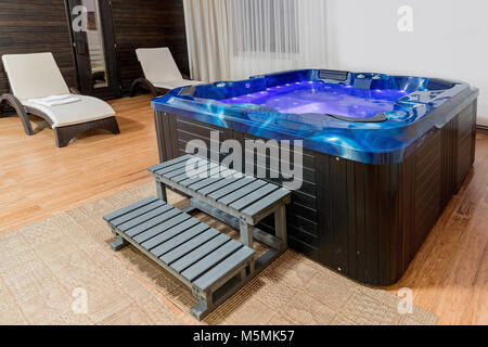 Indoor Jacuzzi suite for relaxation on roof. Blue whirpool jacuzzi inside. Stock Photo