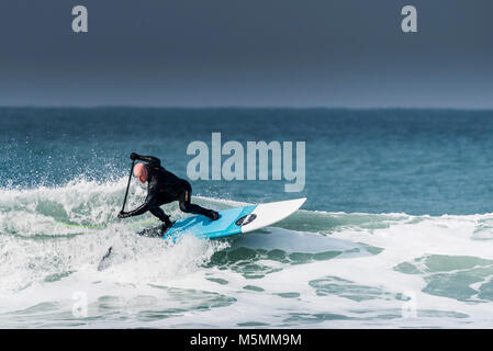 A paddle boarder riding a wave at Fistral in Newquay, Cornwall. Stock Photo