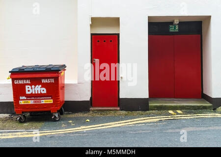 Two red doors and a red Biffa commercial waste bin. Stock Photo