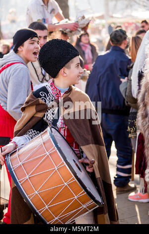 PERNIK, BULGARIA - JANUARY 26, 2018: Boy plays loud drum music and has fun with other musicians of his Kuker group at the annual International Festiva Stock Photo