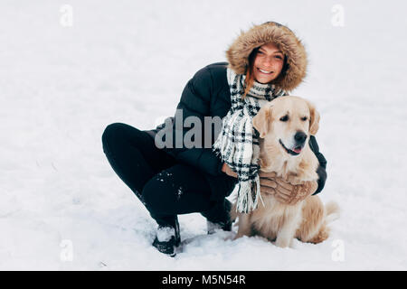 Photo of smiling woman with labrador in winter park Stock Photo