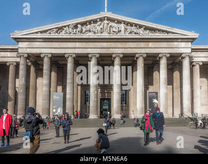 Main entrance to the British Museum (dedicated to human history, art and culture), with visitors outside in winter sunshine. London, England, UK. Stock Photo