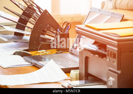 Office workplace with laptop, printer, stand for papers and business papers on the table Stock Photo