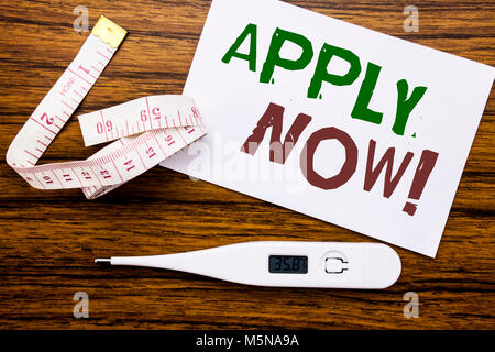 Conceptual hand writing text caption showing Apply Now. Business concept for Job Hiring Application  written on sticky note paper wood background. Met Stock Photo