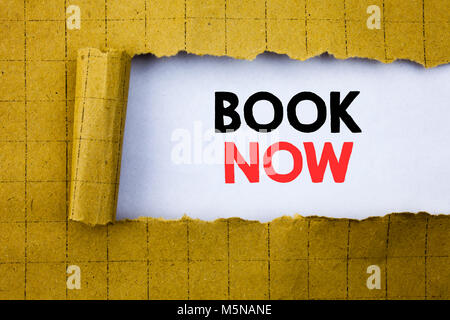 Book Now. Business concept for Reservation Buy Booking written on white paper on yellow folded paper. Stock Photo