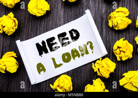Writing text showing Need A Loan Question. Business concept for Mortage Credit Written on sticky note notepad notebook book wooden background with yel Stock Photo