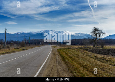 The road goes into the distance against the background of the mountains Stock Photo