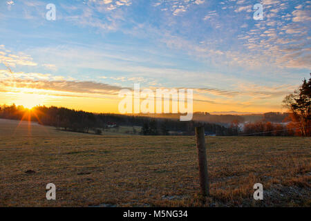 Amazing winter sunrise on Czech countryside with sunrays shine through trees Stock Photo