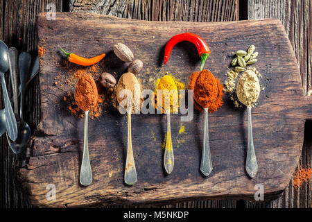 Tasty spices and herbs on old board Stock Photo