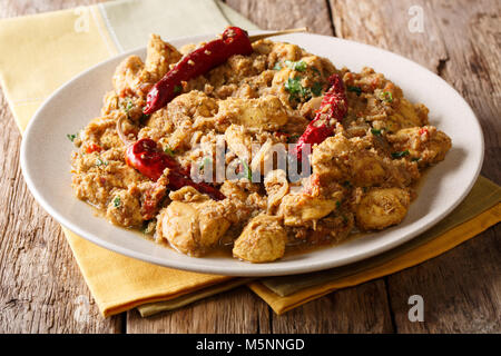 Homemade chicken curry with a dry chili closeup on a plate on a table. horizontal Stock Photo