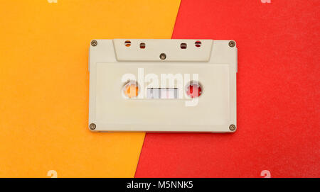 Retro audio compact cassette on yellow red background. Stock Photo