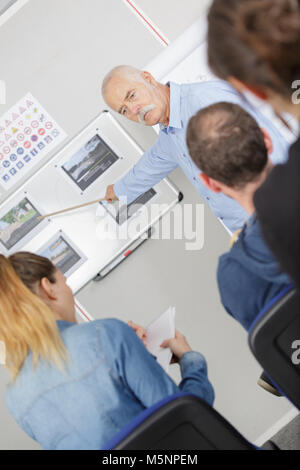 Road safety teacher pointing to scene on board Stock Photo