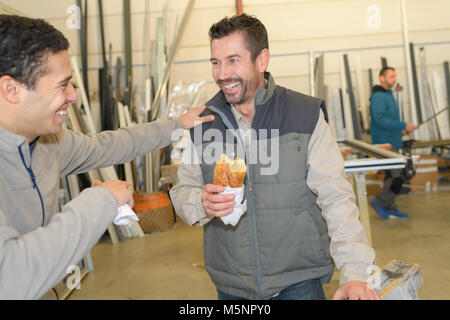two happy engineers eating lunch while laughing Stock Photo