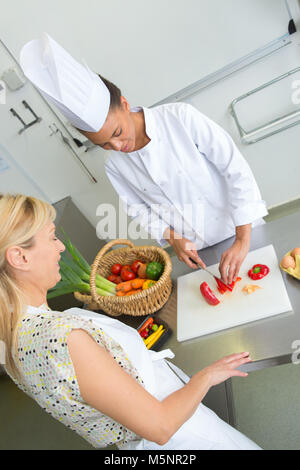 friendly smiling female chefs preparing food on restaurant kitchen Stock Photo