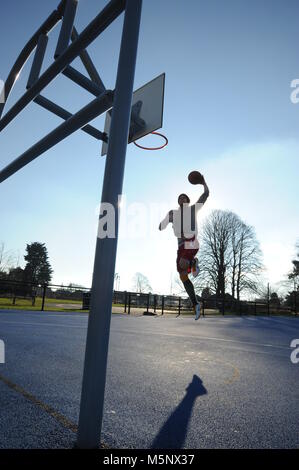 An outdoor shoot of a basketball player in Devizes, Wiltshire. Shot in natural sunlight on a basketball court. Wide depth of filed, good lighting.