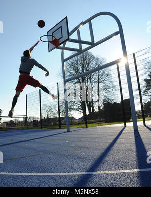 An outdoor shoot of a basketball player in Devizes, Wiltshire. Shot in natural sunlight on a basketball court. Wide depth of filed, good lighting. Stock Photo