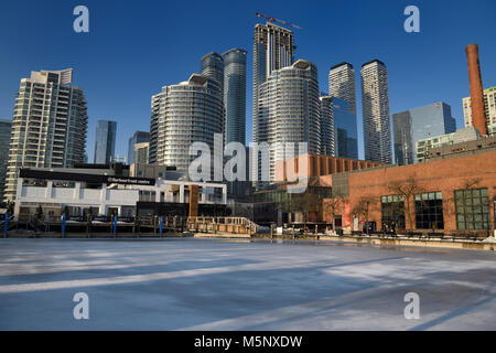 Empty Harbourfront Centre Natrel Pond skating rink with highrise condominium towers and Power Plant contemporary art gallery Toronto in winter Stock Photo