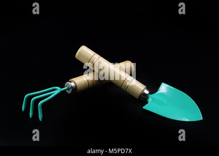 Gardening tools, rake and scoop isolated on black background Stock Photo