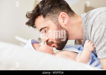 Man as happy father lovingly kisses his newborn baby Stock Photo