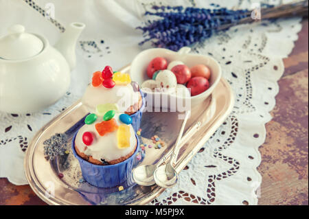 Easter cakes with icing and marmalade decoration and caramel marzipan eggs in a box. Easter decor. Close up. Copy space. Stock Photo