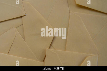 Background full of letters envelopes. Made of pastel orange paper. Stock Photo