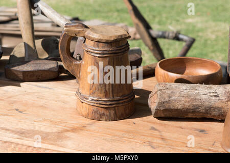 An old fashion wooden beer tankard on a wooden table part of a display at an American revolution reenactment . Stock Photo