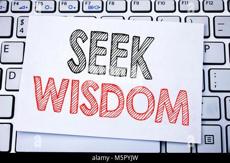 Handwritten text caption showing Seek Wisdom. Business concept writing for Inspiration Knowledge written on sticky note paper on white keyboard backgr Stock Photo
