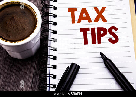 Writing text showing Tax Tips. Business concept for Tip Forn Taxes written on notebook book note paper on wooden wood background. With coffee and blac Stock Photo