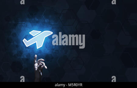 Airplane glowing icon touched with finger as online booking concept Stock Photo