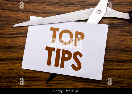 Hand writing text caption inspiration showing Top Tips. Business concept for Expert Tip Guidance Written on note, wooden with colourful scissors meani Stock Photo
