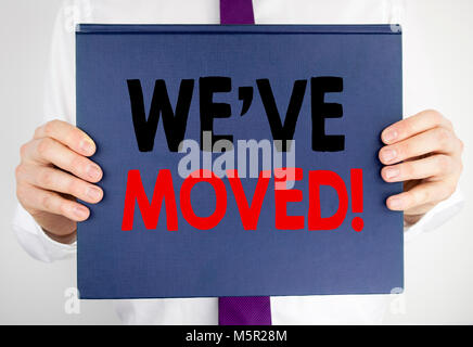 Writing text showing We Have Moved. Business concept for Company Changing Place written on book notebook paper holding by man in suit blurred backgrou Stock Photo