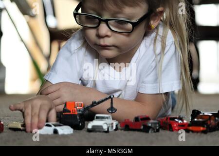 Girl enjoys playing with her toy cars Stock Photo - Alamy