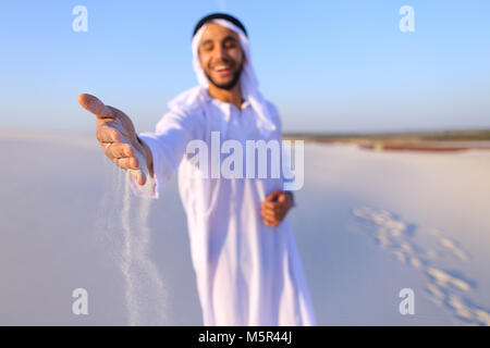 Close-up shot of portrait and hands of young Arab guy in sandy d Stock Photo