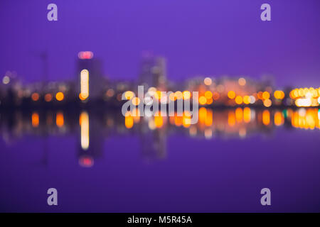 Abstract Blurred Bokeh Architectural Urban Backdrop With Reflections In Water. Real Blurred Colorful Bokeh Background With Defocused Lights. Toned Pho Stock Photo
